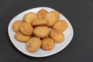 Homemade shortcrust pastry cookies on white plate. Baking for tea. Appetizing cookies. Gray background.