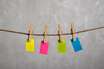 Small multicolored notes hang with clothespins on rope. Copy space. Place for your text. Note, reminder