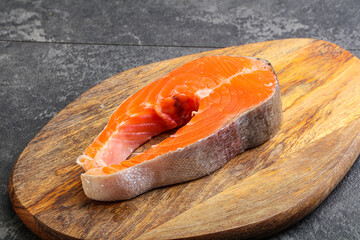 Raw salmon steak over board