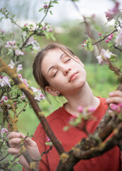 Young teenage girl in a blooming garden