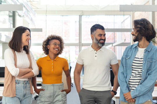 Smiling multiracial group of adult coworkers relaxing in bright coworking space. - Powered by Adobe