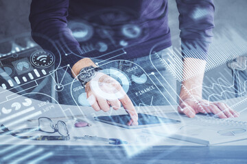 Double exposure of man's hands holding and using a digital device and tech theme hologram drawing. Technology concept.