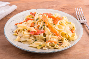Pasta with cream sauce with bell pepper on a plate, close-up - fettuccine with bell pepper