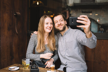 Happy couple taking selfie together in cafeteria