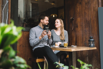 Delighted couple with retro camera in cafeteria