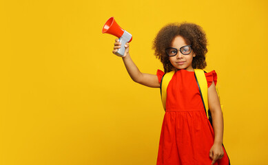 Little cute Black girl in red dress holding in hand and speaking in electronic red and gray...