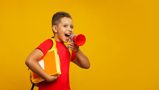 Little cute Black boyl in red T shirt holding in hand and speaking in electronic red megaphone