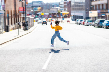 Curly young woman running across the street