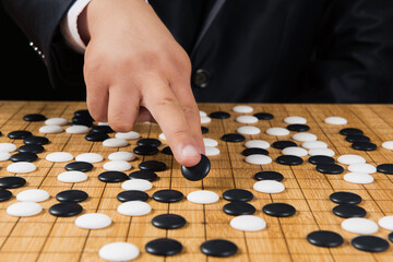 close up of player hand make a move in Go game(Weiqi),Traditional asian strategy board game