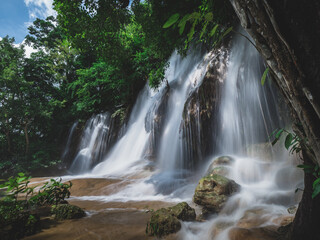 Naklejka premium Scenic waterfall in lush rainforest. Sai Yok Noi Waterfall, Kanchanaburi, Thailand