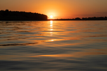 Fototapeta premium Red sunset on the river. Evening. The rays of the sun in the clouds