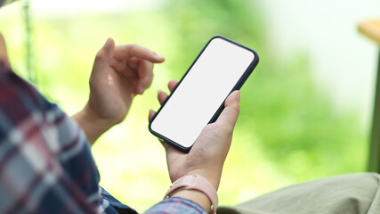 Female checking her social network via mobile phone at the park