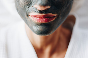 Woman relaxing with a charcoal facial mask