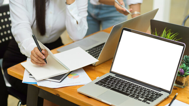 new employee sit and listen manager explain work scope while take note on planner with laptop in empty screen