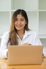 Portrait of beautiful female sitting in front of computer laptop, business female portrait