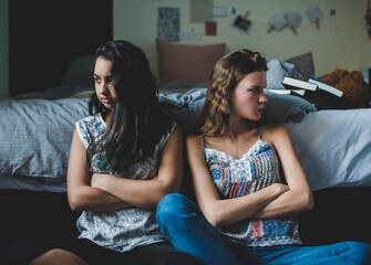 Girl friends with arms crossed looking upset