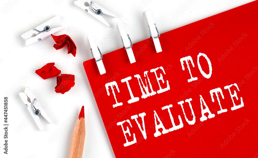 Poster time to evaluate text on red paper with office tools on white background