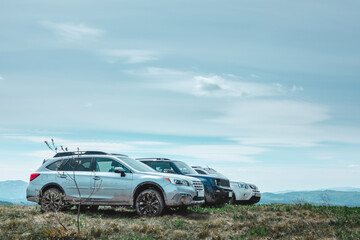 three suv cars at mountains peak