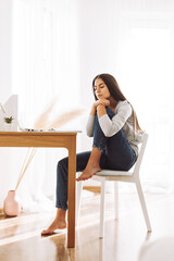 A student girl rests with her eyes closed, resting her head on her knees, while preparing for lectures or exams