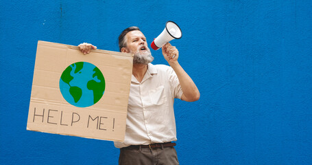 Middle-aged Caucasian man with a megaphone protesting climate change on a blue wall....