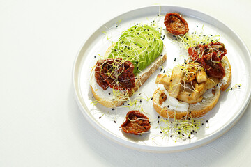 Vegan toast for breakfast, snack or dinner, based on avocado and dried tomato.