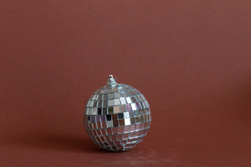 silver glass disco ball on brown background 
