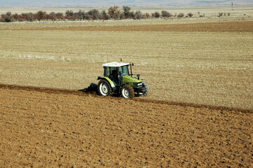 photo of green tractor plowing the field