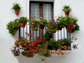 Blumentöpfe an Hauswand in spanischem Dorf