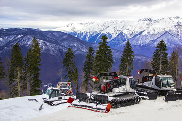snow-removing machines in a ski resort on the background of mountains