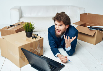 business man in front of laptop moving box with things