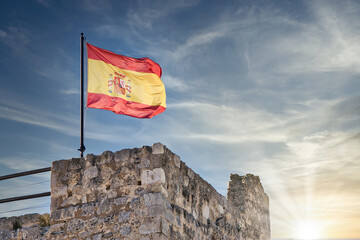 Bandera de España ondeando al viento en lo alto de la torre castillo de Trigueros del Valle, Castilla y León