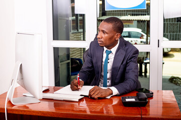 young serious businessman working on laptop in office.