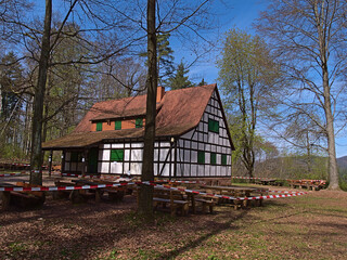 Closed restaurant in historic half-timbered building surrounded by trees in spring season near...
