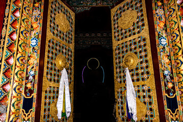 Buddhist monastery entry gate with art work at day from low angle