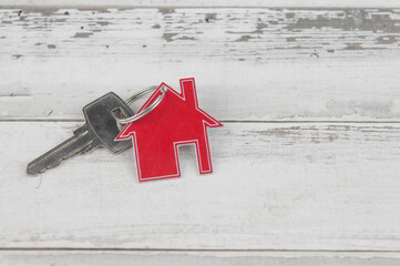 Key and house shaped keychain arrangement on old white wood  background. Top view, flat lay. Real...