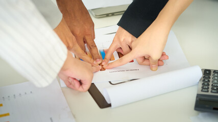 Close-up of group Business people hands pointing analyzing at the documents income charts and graphs while discussing on meeting table