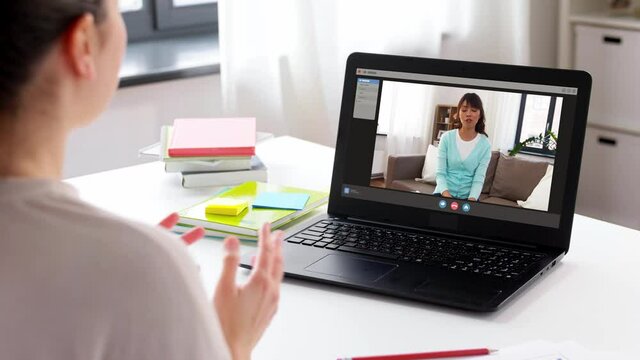 communication, technology and people concept - woman with laptop computer having video call with friend at home