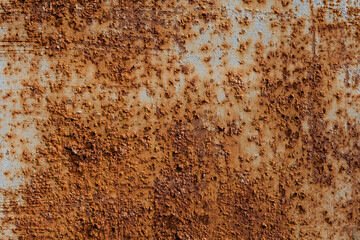 The rusty metal fence is covered with pimples. The aging process of iron. Metal oxidizes and...