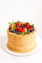 The cake is decorated with strawberry blueberries mint front view close-up