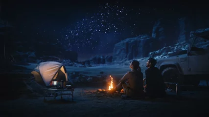 Keuken spatwand met foto Gelukkig paar tent kamperen in de Canyon, zittend bij kampvuur kijken naar de nachtelijke hemel met de Melkweg vol met heldere sterren. Twee verliefde reizigers op een romantische vakantiereis. Achteraanzicht Shot © Gorodenkoff