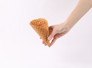 Hand holds waffle cone on white background