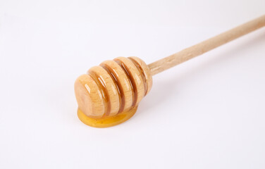 Honey bee spoon with liquid honey on white background.