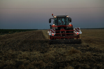 combine harvester in the field at evening