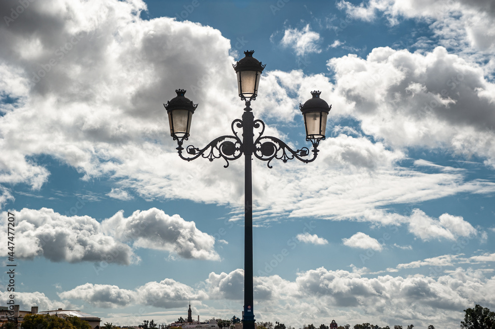 Wall mural photograph taken of the lamppost of the isabel ii bridge, triana bridge, and the guadalquivir river 