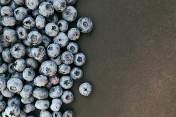Blueberries ripe and tasty on a black background. Top view, rustic style.