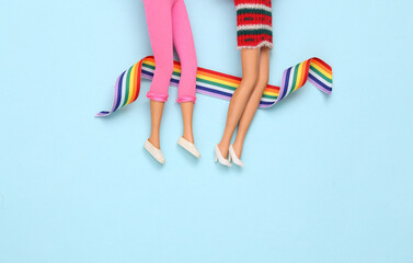 Doll female legs with lgbt rainbow tape on blue background. Creative minimalistic layout