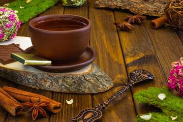 tea in a clay cup on a wooden stand wooden table cinnamon anise spices oriental spoon turkish pattern oriental tea party chocolate drink tea