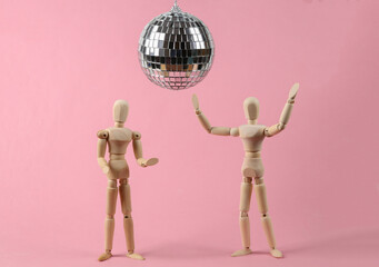 Two puppets dancing under disco ball on pink background. Minimalism party concept