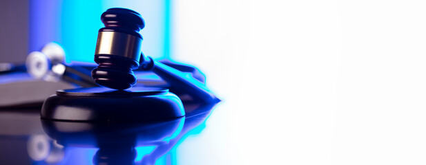 Medical law concept. Gavel, legal code and stethoscope on the glass table. Blue light.