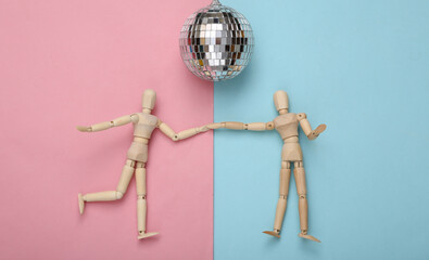 Two puppets dancing under disco ball on blue pink background. Minimalism party concept. Top view